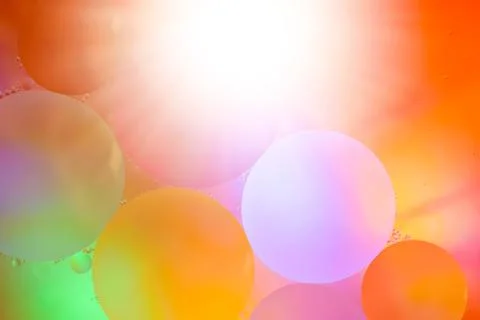 Top view movement of bubbles in the liquid. Oil surface multicolored backgrou Stock Photos