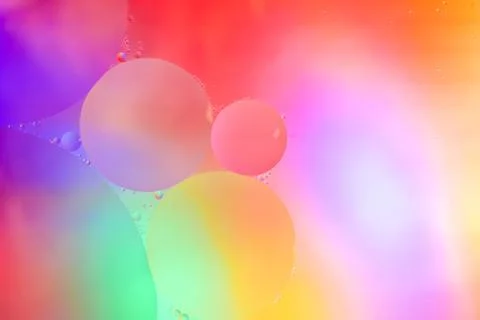 Top view movement of bubbles in the liquid. Oil surface multicolored backgrou Stock Photos