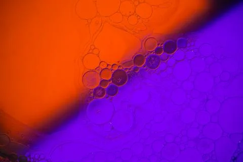 Top view movement of bubbles in the liquid. Oil surface multicolored backgr.. Stock Photos