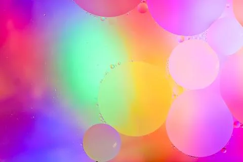 Top view movement of bubbles in the liquid. Oil surface multicolored backgr.. Stock Photos