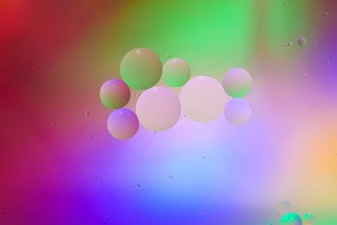 Top view movement of bubbles in the liquid. Oil surface multicolored backgr.. Stock Photos