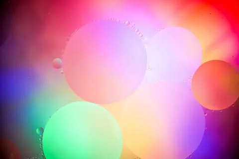 Top view movement of bubbles in the liquid. Oil surface multicolored backgr.. Stock Photos