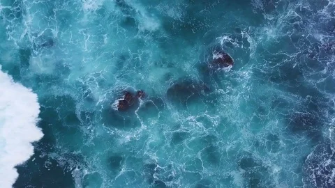 Top view moving up away ocean blue waves crash coastline cliff drone footage Stock Footage 84785598