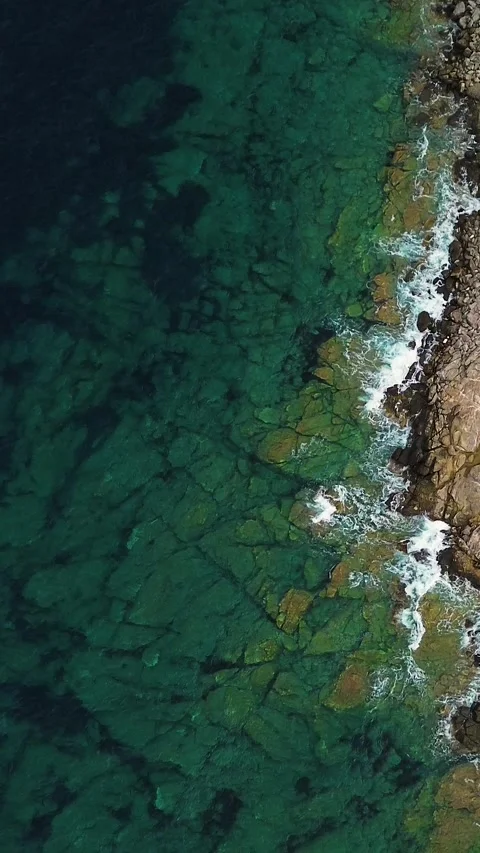 Top View Moving Over Rocky Shoreline and Turquoise Sea Stock Footage 342238260