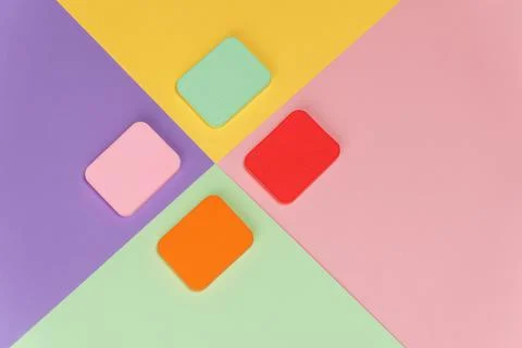 Top view of multi-colored sponges on different pastel-colored backgrounds. Ab Fotos de archivo