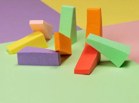 Top view of multi-colored sponges on different pastel-colored backgrounds. Ab Фото