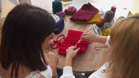 Top view of multi-ethnic friends learning how to crochet together Stock Footage 130605783