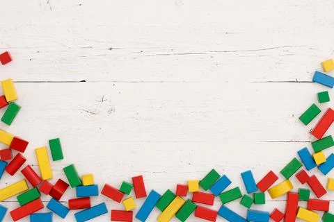 Top view of multicolored educational cubes scattered on a white wooden backgr Stock Photos
