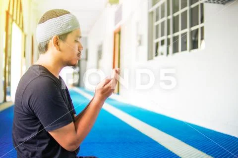 Top view of muslim man making du'a praying on praying mat inside a mosque Stock Photos
