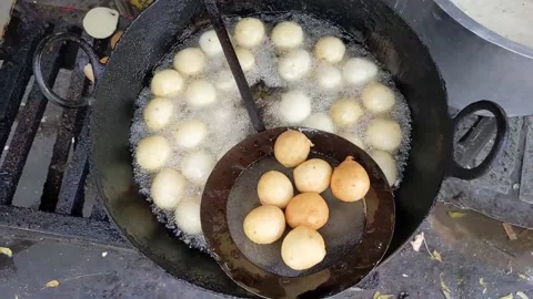 Top view of Mysore Bajji, an Indian snack, being fried in a pan Stock Footage 166085181