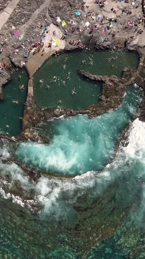 Top view of natural pool with unrecognizable people sunbathing and swimming Stock Footage 280025941