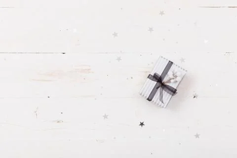 Top view on nice Christmas gift packed in striped paper on wooden background. Stock Photos