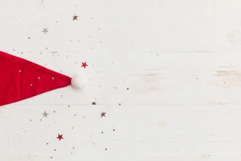 Top view on nice Santa's hat on wooden background with sparkling stars. Stock Photos