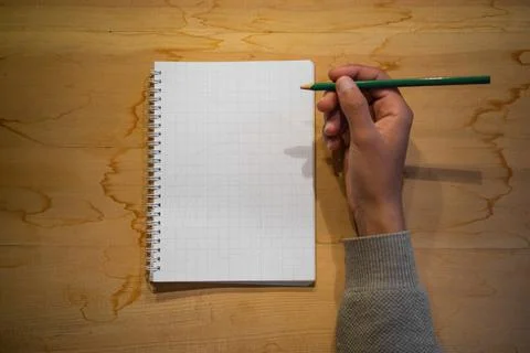 Top view of note book with hand on wood background office desk 库存照片