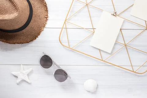 Top view note pad clip frame and summer straw hat with sunglasses on white wo Stock Photos