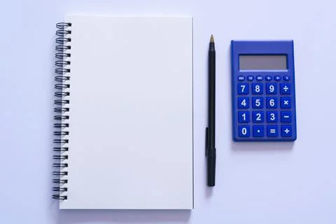 Top view of note pad, pen, and calculator on white background Stock Photos