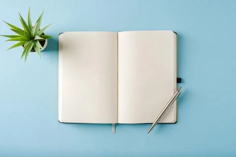 Top view of notebook and ballpoint pen on blue background Stock Photos