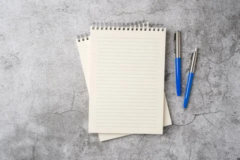 Top view of notebook and ballpoint pen on stone background Stock Photos