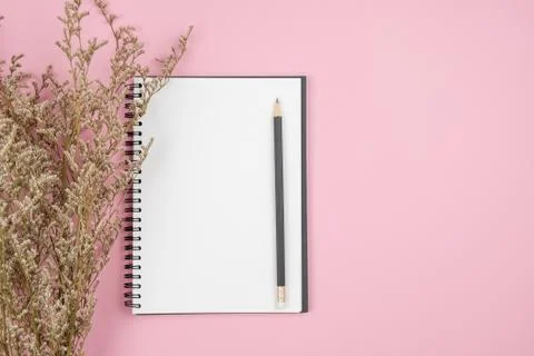 Top view of notebook and flower on pink background Stock Photos