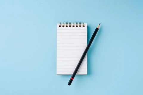 Top view of notebook and pencil on blue background Stock Photos