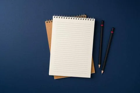 Top view of notebook and pencil on blue background Stock Photos
