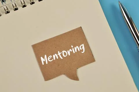 Top view of notebook and speech bubble note written with MENTORING Stock-Fotos