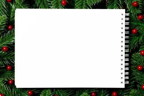Top view of notebook decorated with a frame made of fir tree on wooden back.. Stock Photos