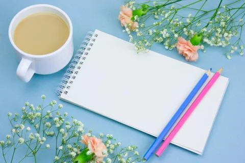 Top view notebook with empty white paper sheet ,colored pencils,coffe with cr Stock Photos