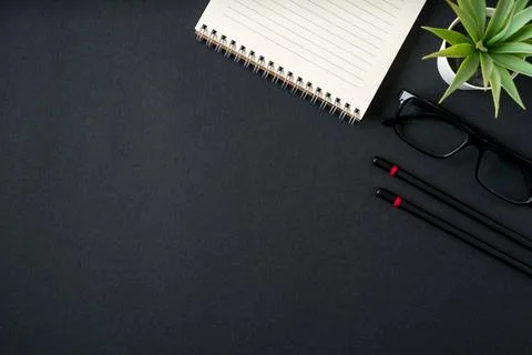 Top view of notebook, glasses and ballpoint pen on dark grey background 스톡 사진