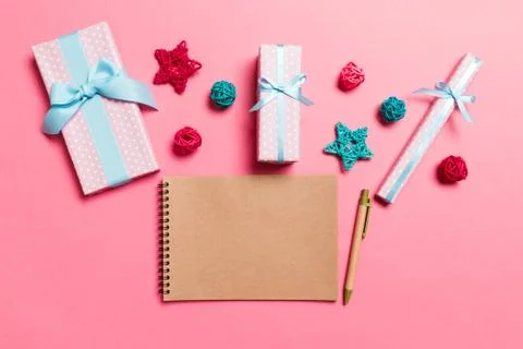 Top view of notebook on pink background made of Christmas decorations. New Ye Stock Photos