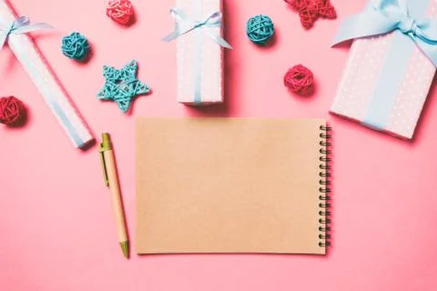 Top view of notebook on pink background made of Christmas decorations. New Ye Stock Photos