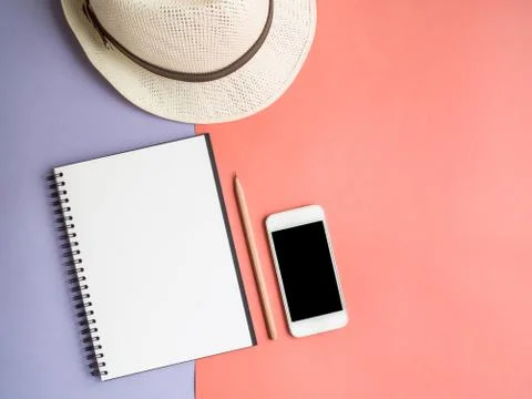 Top view of notebook, smartphone, hat on violet purple background Stock Photos