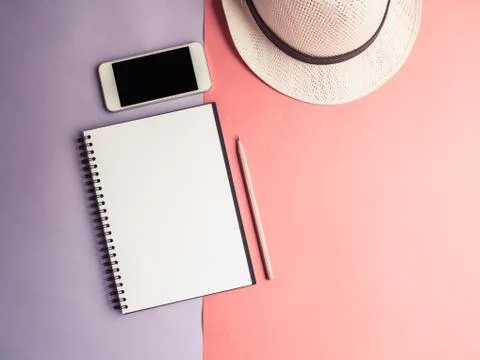 Top view of notebook, smartphone, hat on violet purple background Stock Photos