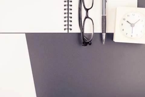 Top view of a notebook with stationery items on black and white background Stock Photos
