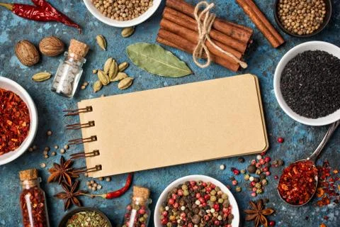 Top view of notebook template with mix bright spices and herbs in small bowls Stock Photos