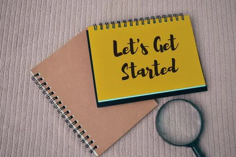 Top view of notebook written with text LET'S GET STARTED. Stock Photos