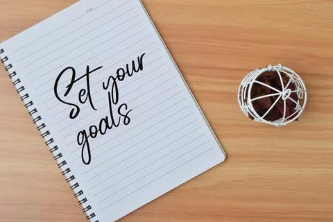 Top view of notebook written with text SET YOUR GOALS. Stock Photos