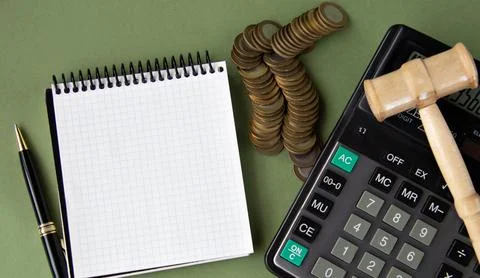 Top view of a notepad, calculator, pen and coins. .And a judge's gavel. Pla.. Stock Photos