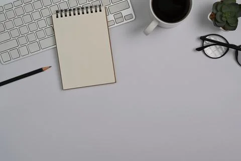 Top view notepad, coffee cup, eyeglasses and succulent plants on white office Stock Photos