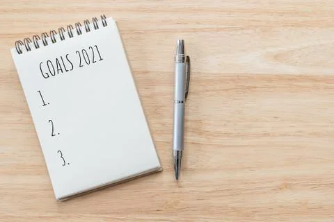 Top view of notepad with Goals List on wooden table, goals concept. Stock Photos