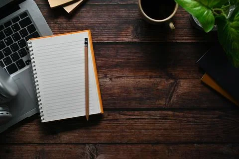 Top view of notepad, laptop computer and headphone wooden table. Space for your Stock Photos