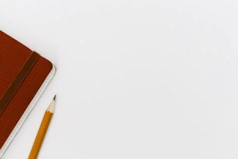 Top view of  notepad with a pencil on a white table background Stock Photos