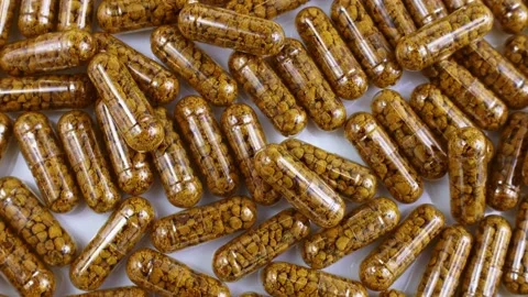 Top view of nutritional supplement capsules with bee pollen inside rotation Stock Footage 233444099