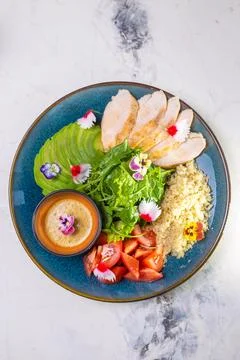 Top view of nutritious lunch with grilled chicken, salad, tomatoes, avocado,  Stock Photos