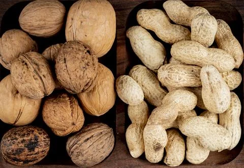Top view of nuts peanuts in shell and whole walnuts on wooden background Stock Photos