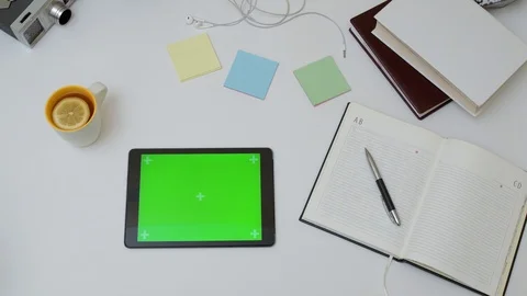 Top view on the office desk and black tablet computer with green screen. Stock Footage 87570324