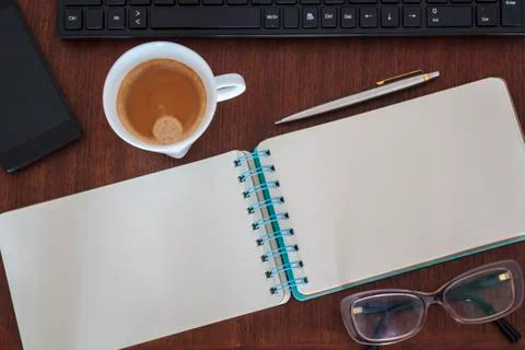 Top view of Office desk with notebook, computer, coffee cup, smartphone and g Stock Photos