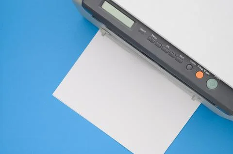 Top view of an office printer and a blank sheet of paper on a blue background. Stock Photos