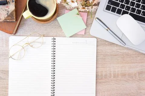 Top view office stuff with notepad, laptop and coffee cup mouse notepad shot. Stock Photos