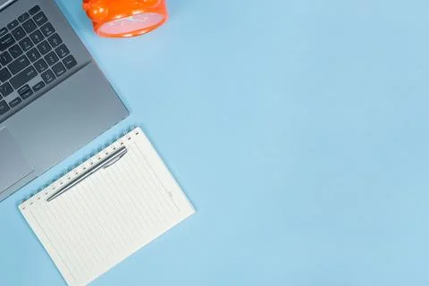 Top view of Office Table top with laptop computer, orange clock and noteboo.. 스톡 사진